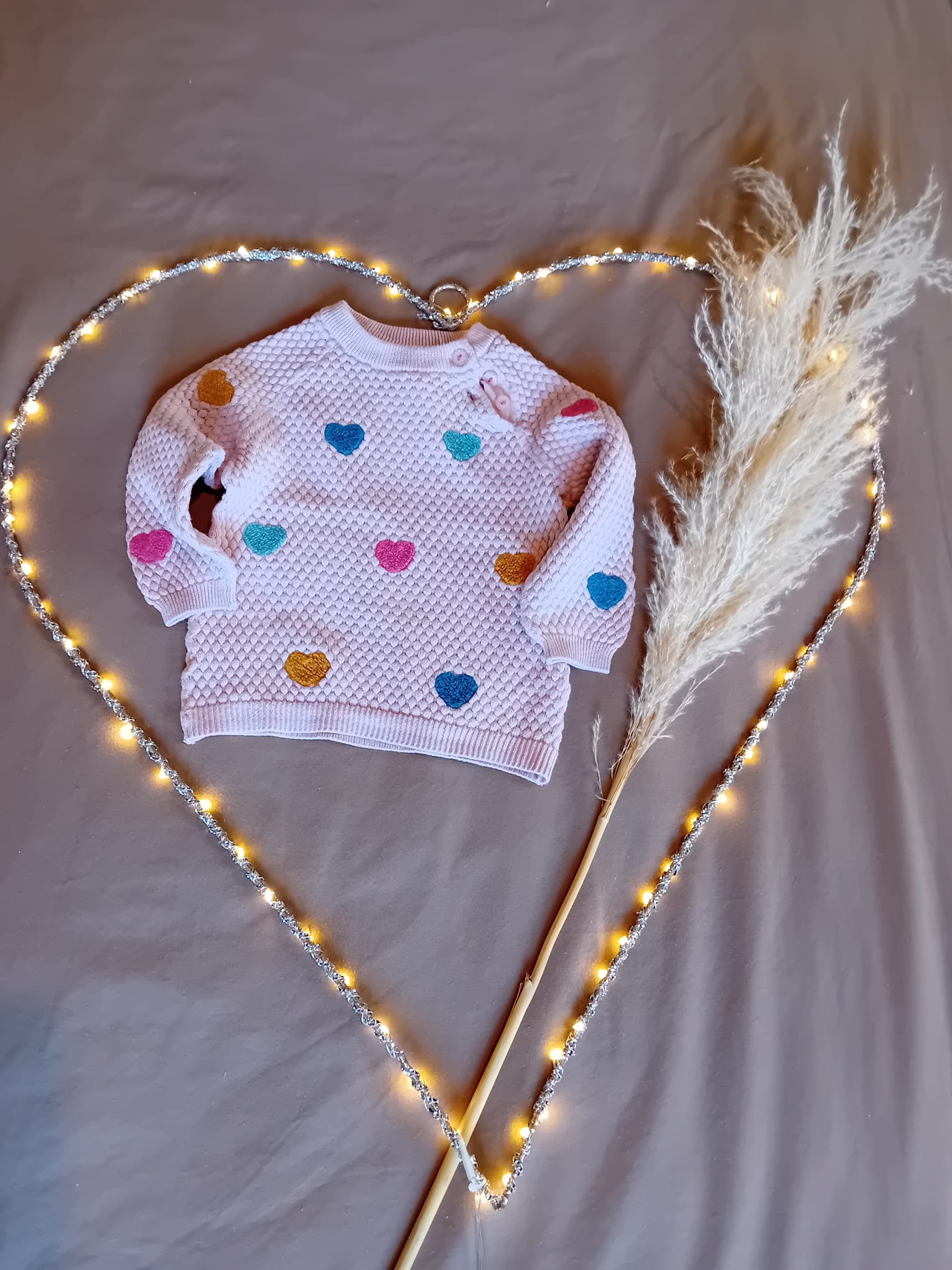 Pull rose avec cœurs colorés 